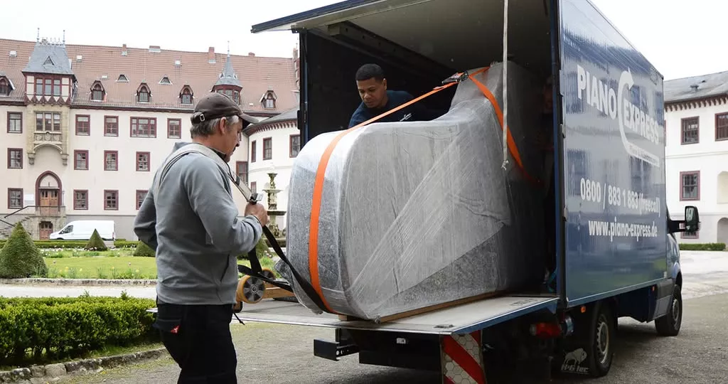 El equipo de Piano-Express carga un piano embalado en el camión